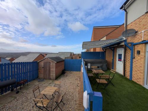 a patio with chairs and tables and a fence at Numero Uno Comfy 3BR 3 Baths Hot Tub wifi Contractor and Group Friendly in Newcastle upon Tyne