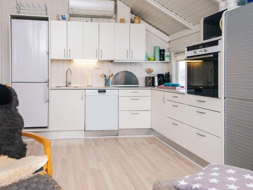 a kitchen with white cabinets and white appliances at 4 star holiday home in Vejers Strand in Vejers Strand