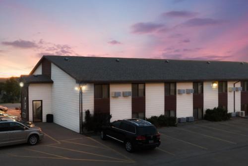 a building with a car parked in a parking lot at Super 8 by Wyndham Chamberlain SD in Chamberlain
