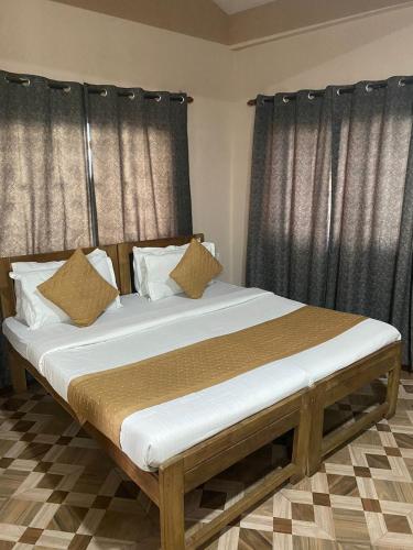 a large bed in a room with black curtains at Hotel Beach Avenue in Calangute
