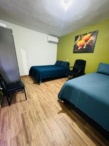 a bedroom with two beds and two chairs in it at Departamento Mateo'S 505 in Ciudad Acuña