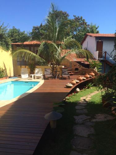 um quintal com uma piscina e um deque de madeira em Pousada Bambu Brasil em Sao Jorge