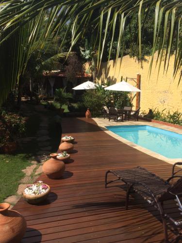 a wooden deck next to a swimming pool with a pool at Pousada Bambu Brasil in Sao Jorge