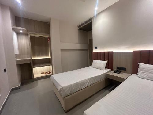 a hotel room with two beds and a small room at Hotel Luxe in Kānpur