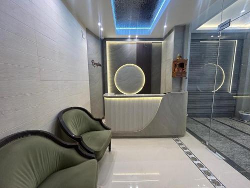 a bathroom with a green chair and a shower at Hotel Luxe in Kānpur