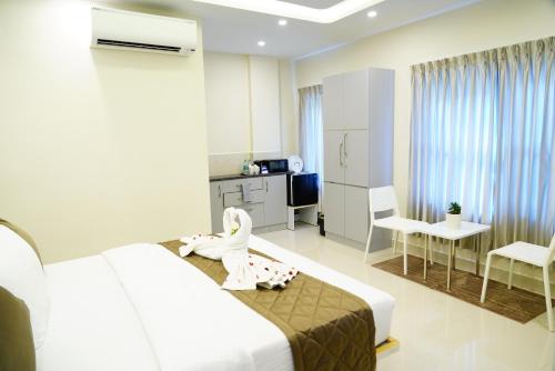 a hotel room with a bed and a child sitting on the bed at Deva Towers in Puttaparthi
