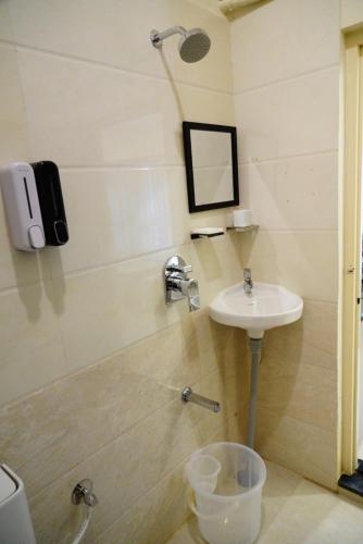 a bathroom with a sink and a shower at Deva Towers in Puttaparthi