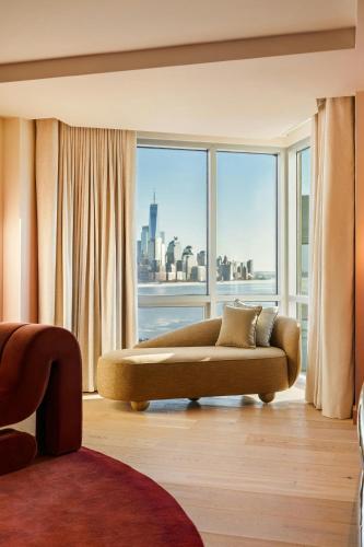 a living room with a couch in front of a window at W Hoboken in Hoboken