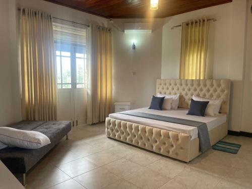 a large bedroom with a large bed and a window at Peak Lodge in Kandy
