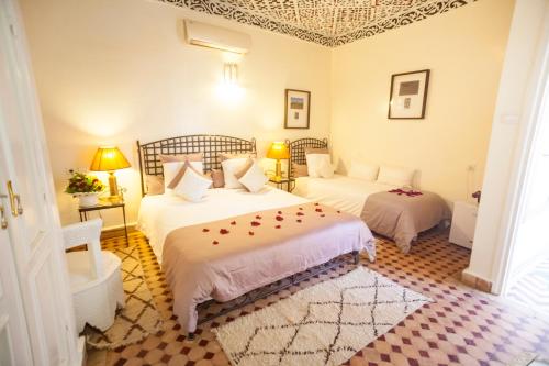 a bedroom with two beds and two lamps in it at Riad Dar Sofian in Zagora