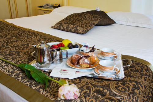 a tray of food and coffee on a bed at Vip's Motel Luxury Accommodation & Spa in Lonato del Garda