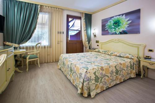 una camera d'albergo con letto e scrivania di Vip's Motel Luxury Accommodation & Spa a Lonato