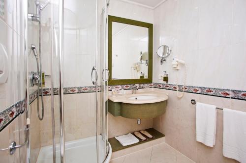 a bathroom with a sink and a shower and a mirror at Vip's Motel Luxury Accommodation & Spa in Lonato del Garda