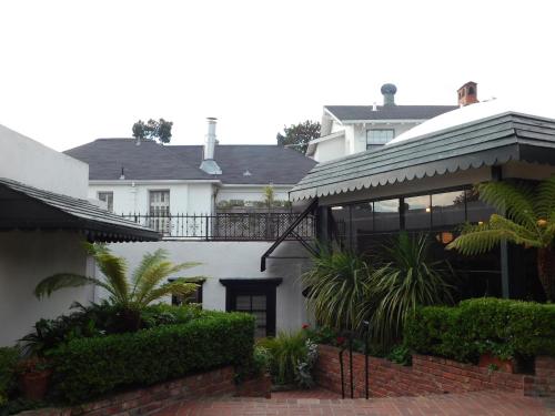 a white house with a balcony and plants at Pine Inn - Carmel in Carmel
