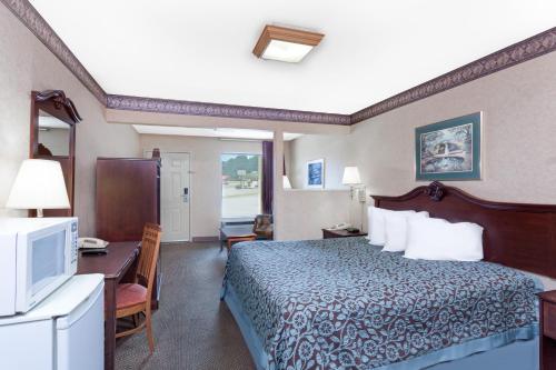 een hotelkamer met een bed, een bureau en een televisie bij Days Inn by Wyndham Morristown in Morristown