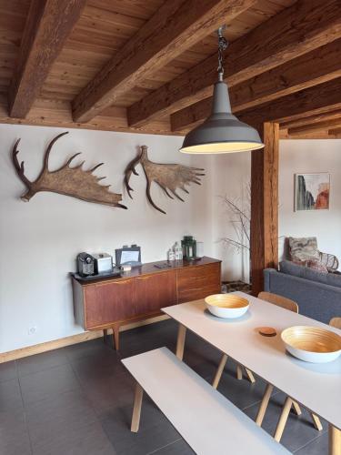 salon ze stołem jadalnym i porożem na ścianie w obiekcie Chalet Moose w mieście Morzine