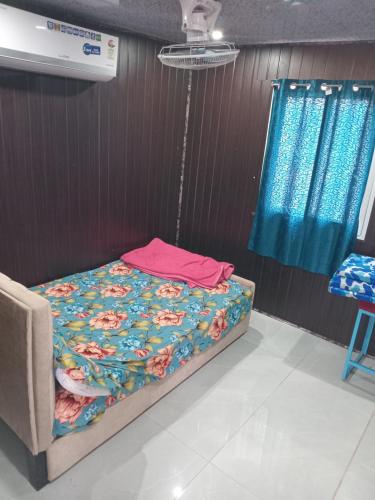 a small bed in a room with at Amigos rooms in Annavaram