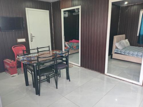 a dining room with a table and chairs and a mirror at Amigos rooms in Annavaram