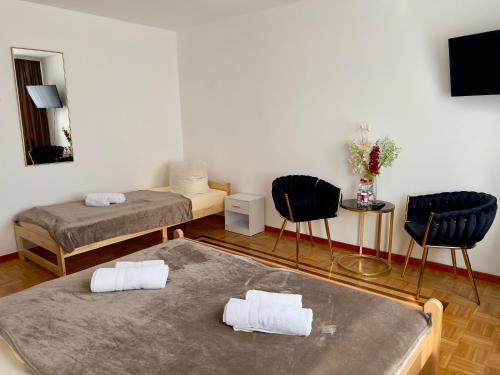 a room with two beds and two chairs at Pension Francesco in Nuremberg