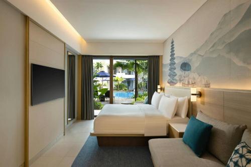 a hotel room with a bed and a couch at Courtyard by Marriott Bali Seminyak Resort in Seminyak