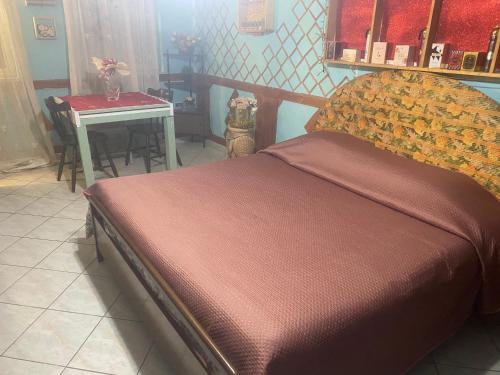 a bed in a room with a table and a table at Home Room in San Pietro Avellana