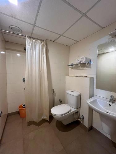 a bathroom with a toilet and a sink and a mirror at HOTEL DWARA in Subrahmanya