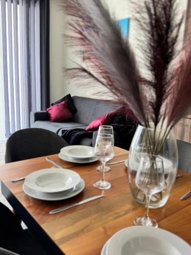 a table with plates and glasses and a vase with feathers at Sea view Mercury Tower, Rooftop infinity Pool in St. Julianʼs