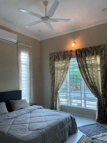 a bedroom with a bed and a ceiling fan at Homestay kampung moden in Pendang