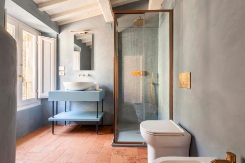 a bathroom with a toilet and a sink and a shower at Romantico appartamento nel centro storico in Cortona