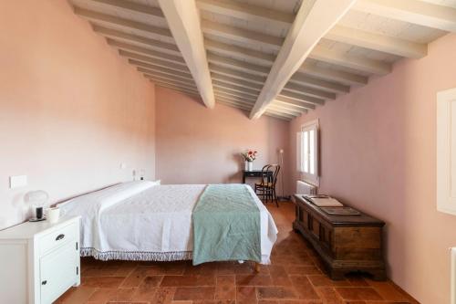 a bedroom with a large bed and a table at Romantico appartamento nel centro storico in Cortona