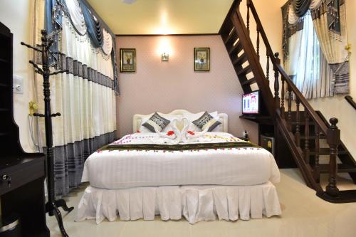 a bedroom with a white bed and a staircase at Holiday Haven Ukulhas in Ukulhas