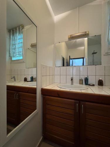a bathroom with a sink and a mirror at Belle maison équipé avec piscine in Mamoudzou