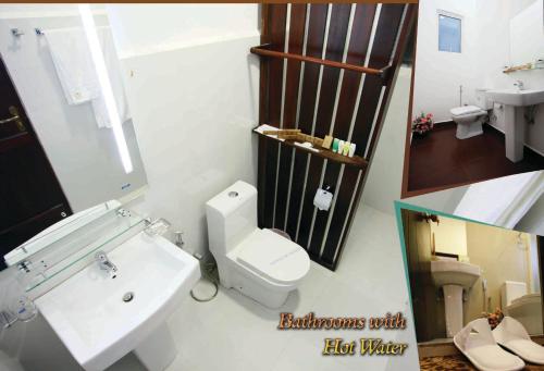 a bathroom with a white toilet and a sink at The Queensburry City Hotel in Nuwara Eliya