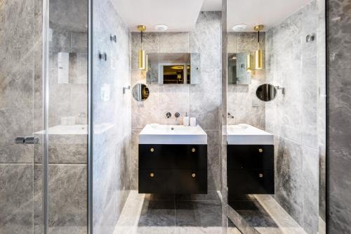 y baño con 2 lavabos y ducha. en Snob Hotel en París
