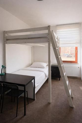a bedroom with a bunk bed with a table and a desk at JustInRent Next by Gallery Szpitalna 4D-2 in Legnica