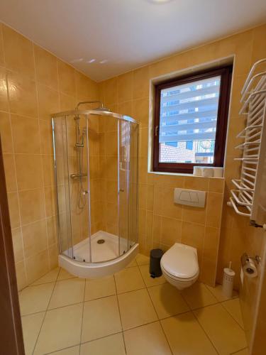a bathroom with a shower and a toilet and a window at JustInRent Next by Gallery Szpitalna 4D-2 in Legnica