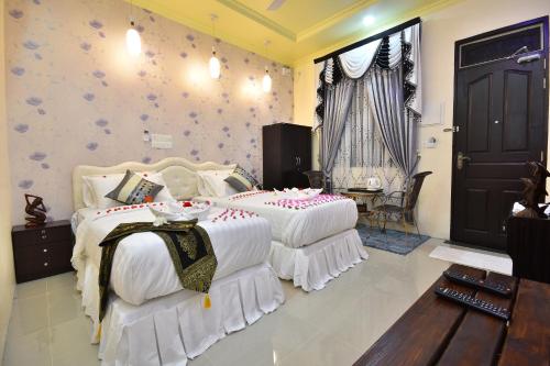 a bedroom with two beds with white comforters at Holiday Haven Ukulhas in Ukulhas