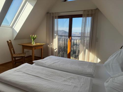 a bedroom with two beds and a table and a window at Weingartenhaus Eckberg41 in Eckberg