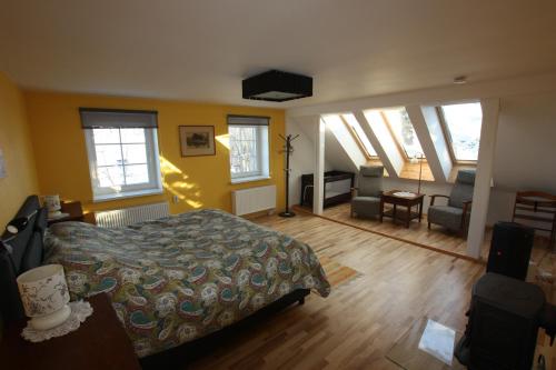 a bedroom with a bed and a living room with windows at Virulase Holiday Home in Toila