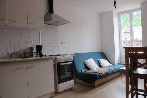 a kitchen with a blue couch in a room at POLIGNY, appartement centre ville in Poligny