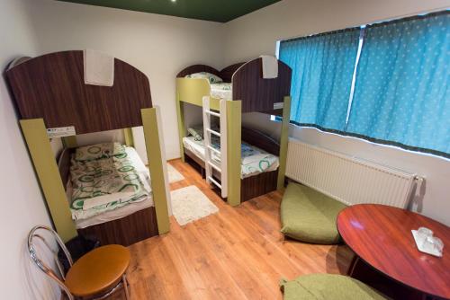 スフントゥ・ゲオルゲにあるGreen Hostelの二段ベッド3組とテーブルが備わる客室です。