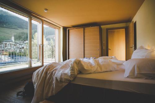 a bed in a room with a large window at Arabella Retreat & Spa in Nauders