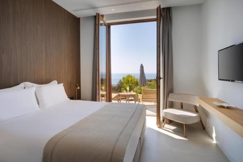 a hotel room with a bed and a sliding glass door at Villa Anthilia in Syvota