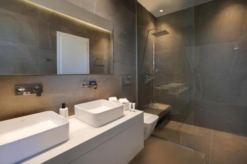 a bathroom with a sink and a mirror and a toilet at Villa Anthilia in Syvota
