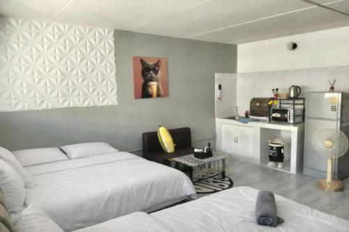 a room with two beds and a dog picture on the wall at IMPACT popular condo c5 แม่ตังค์ in Ban Bang Phang