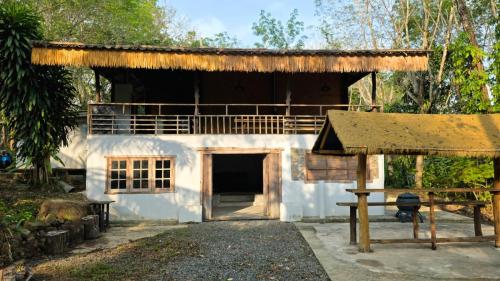 a small house with a thatched roof and a table at Hostel Ko Kut in Ko Kood