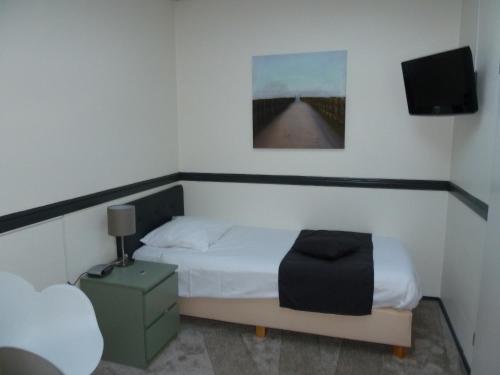 a bedroom with a bed and a television in it at Hotel Centraal in Harlingen