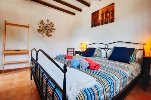 a bedroom with a bed with red and blue pillows at Gusta la Vista in Ríogordo