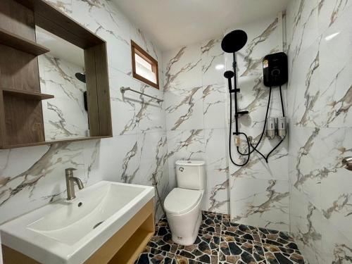 a white bathroom with a sink and a toilet at เขาลมเย็น in Khao Kho