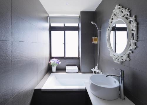 a bathroom with a white sink and a mirror at Herb Art Hotel in Keelung